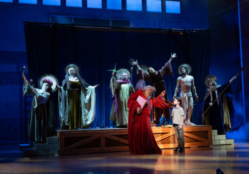 Keenan Barrett as Damian onstage surrounded by saints in the Alliance's production of MILLIONS – photo by Greg Mooney.