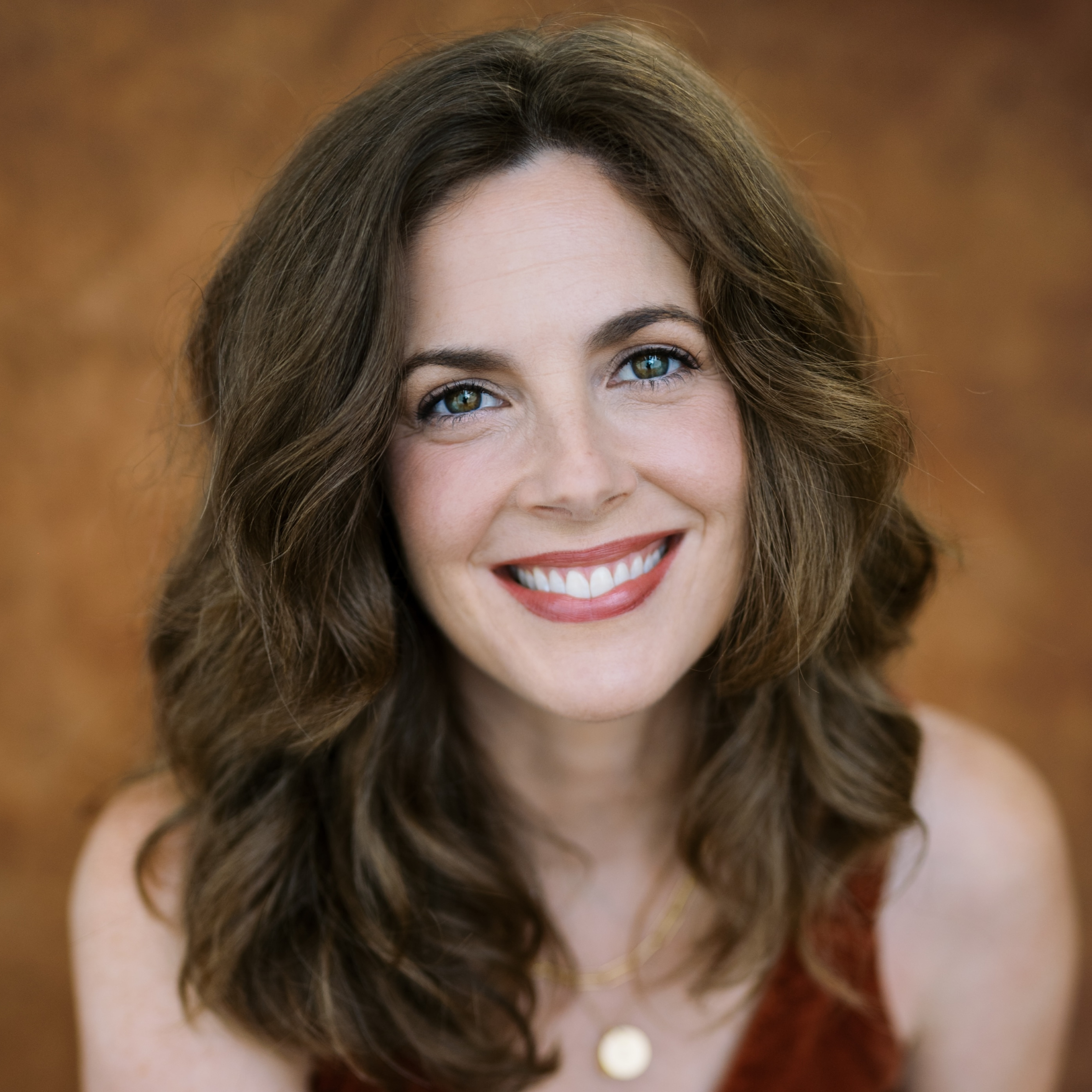 Headshot of a smiling woman with shoulder-length brown hair.