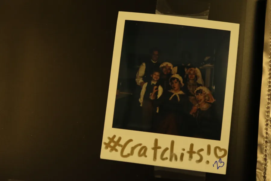 A Polaroid photo labeled "#Cratchits!" shows five people dressed in period costumes, taped to a dark surface.