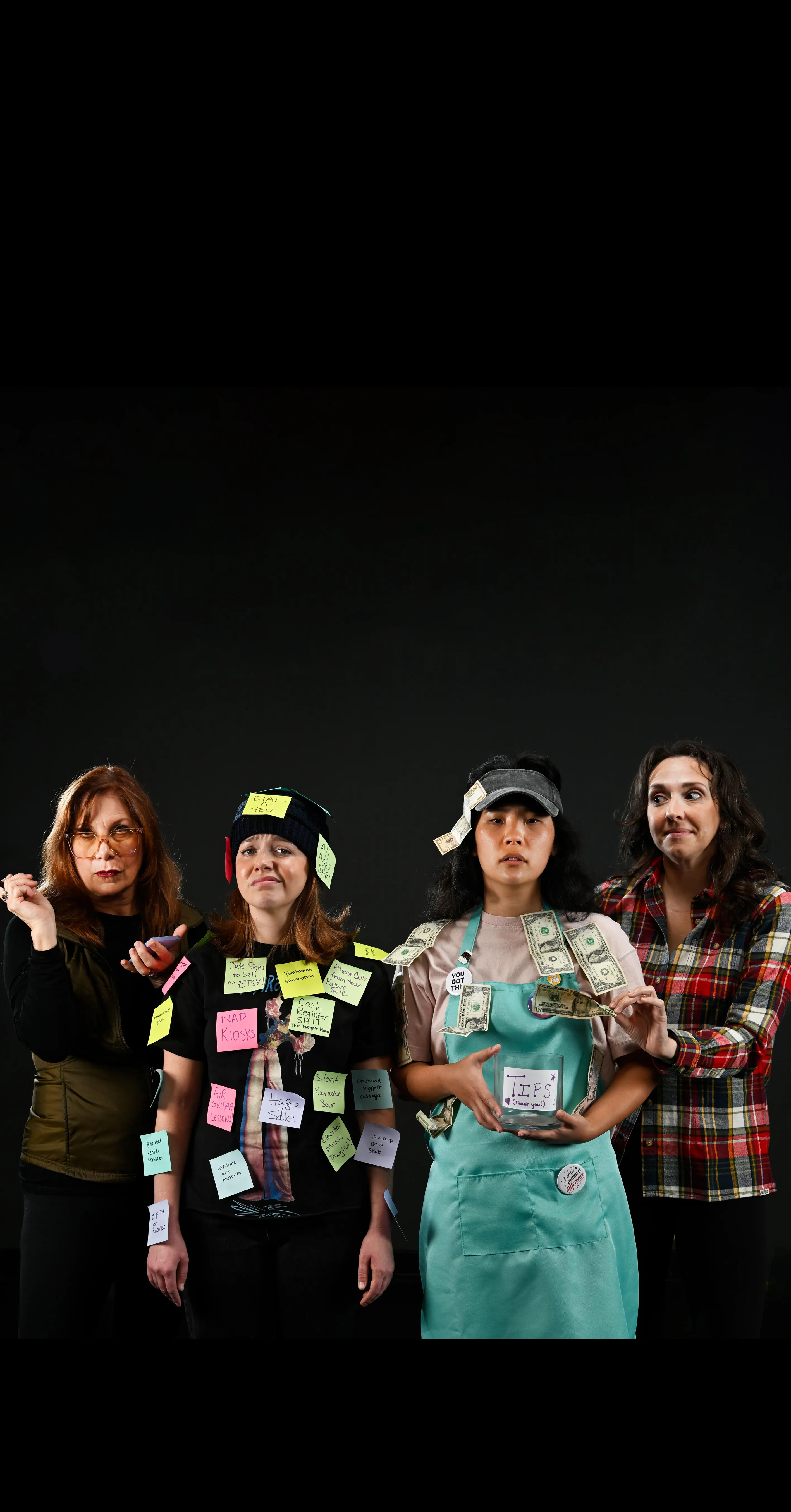 Four women stand in a row against a black background; two are covered in sticky notes, one holds a box with cash pinned to her, and one wears a plaid shirt and looks on.