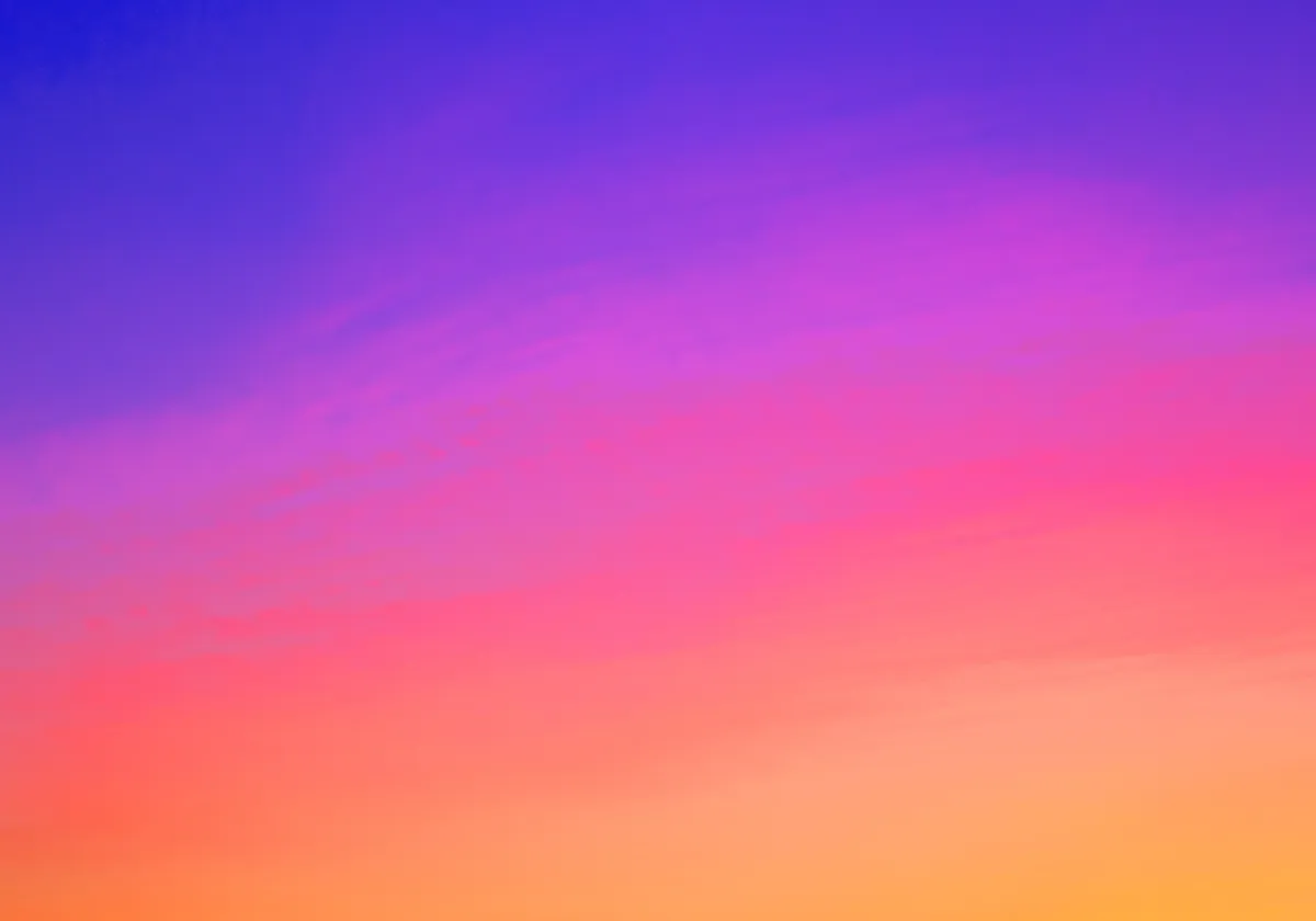 A gradient sky with vivid colors transitioning from blue and purple at the top to pink, orange, and yellow at the bottom.