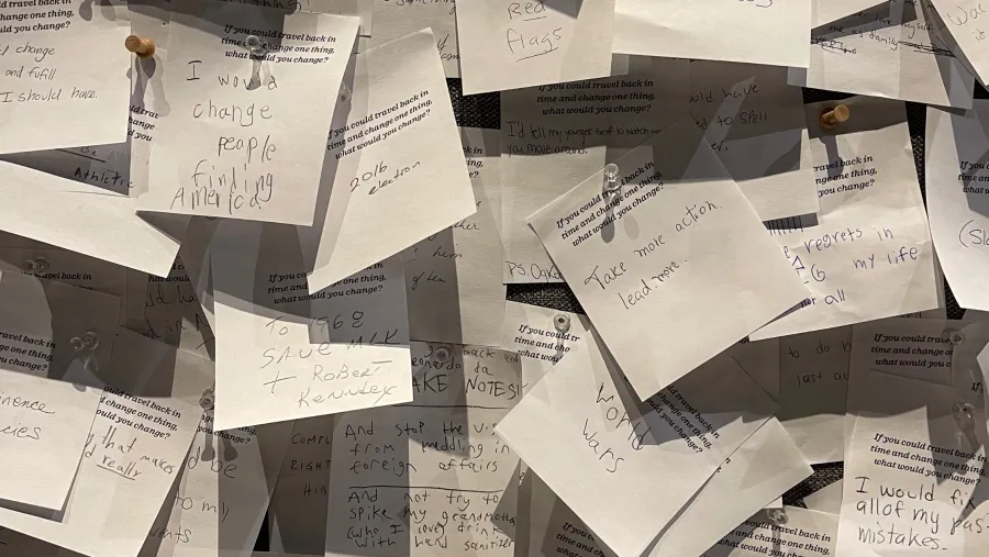 Several handwritten notes are pinned to a board, overlapping each other, each containing personal reflections or messages.
