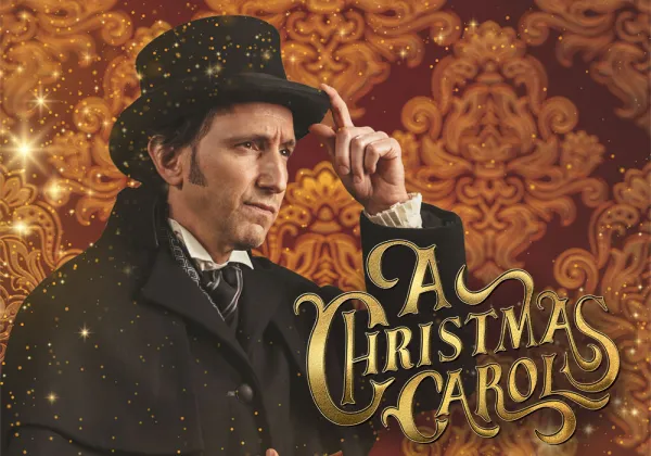 A man in Victorian attire and top hat poses against an ornate background with gold sparkles. Text reads "A Christmas Carol.