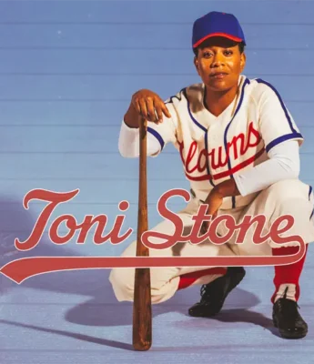 A baseball player in a white and red uniform with "Clowns" lettering kneels on one knee holding a bat, with the text "Toni Stone" across the image.