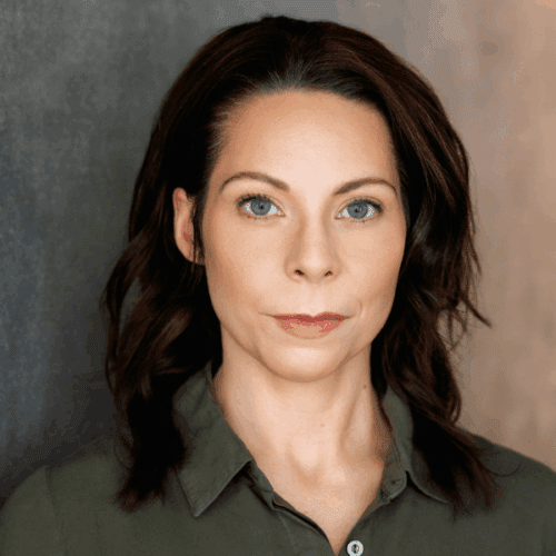 A woman with fair skin, blue eyes, and dark brown hair looks directly at the camera, wearing a green collared shirt, against a neutral background.