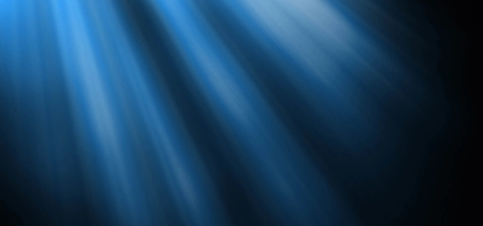 Blue light rays shine through darkness, creating a soft, abstract pattern with a gradient from bright to dark blue.
